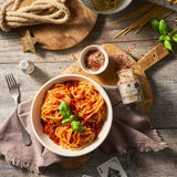 Pasta mit Tomatensauce auf einem Teller angerichtet und im Western-Style dekoriert.